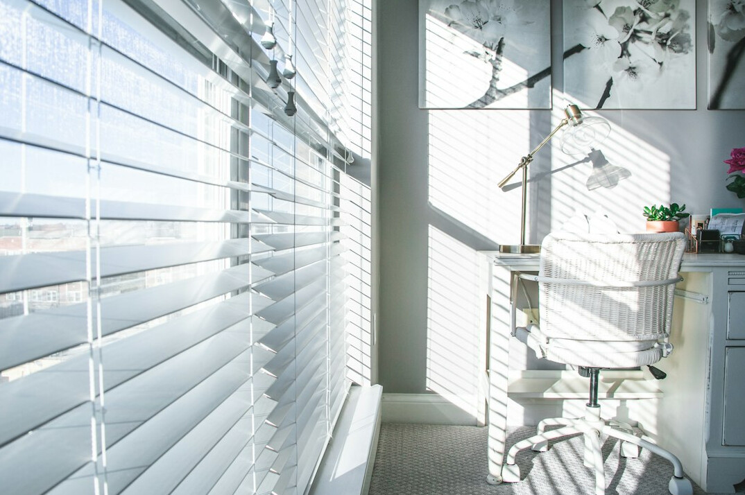 Bright boutique office interior with linen curtains and ocean light